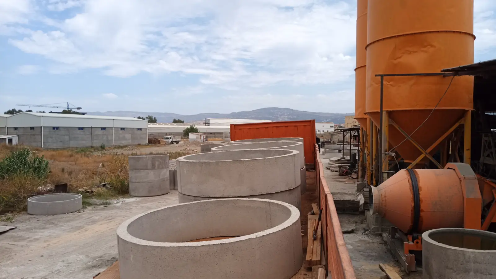 Malaxeur et silos à côté d'un camion chargé de regards ronds